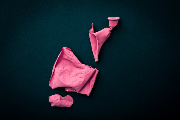 黑色背景上破损的粉色心形气球图片下载