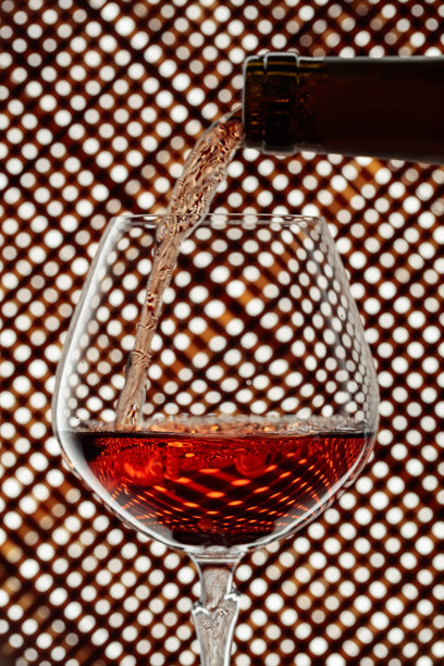 白兰地倒进玻璃杯里。图片下载
