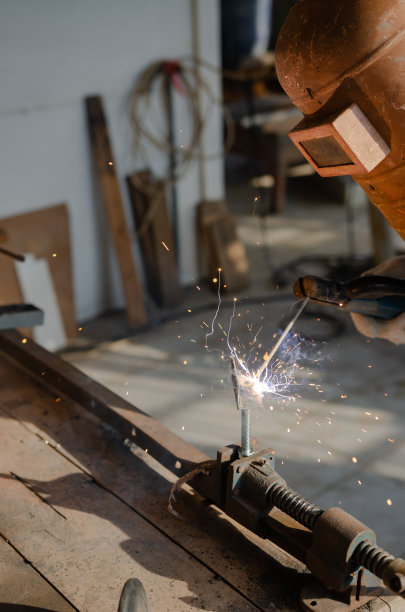 在他的工作室里从事焊接钢铁的业余爱好的年轻人图片下载