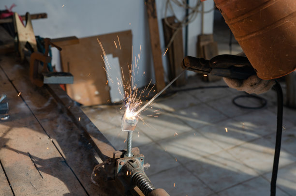 在他的工作室里从事焊接钢铁的业余爱好的年轻人图片下载