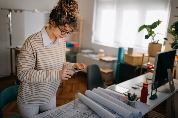 女商人用智能手机拍摄蓝图图片下载
