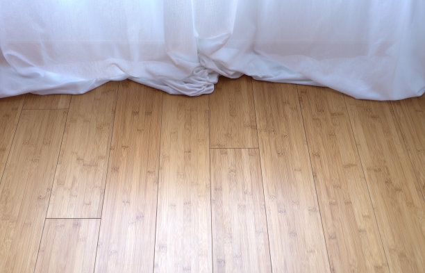 白色窗帘拖在竹制拼花地板上图片下载