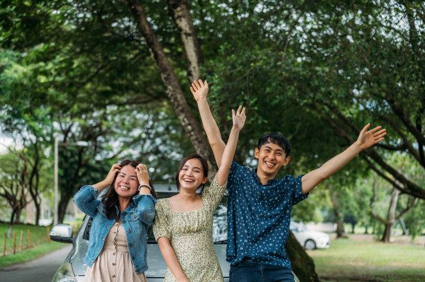 三个朋友在公路旅行休息，靠在车里对着镜头挥手图片下载