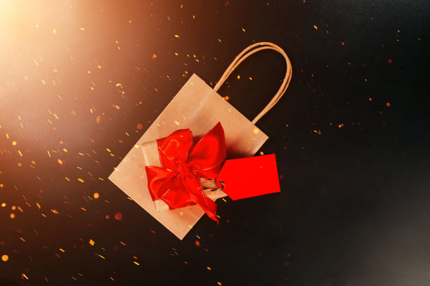 红色背景的礼品盒。极简主义风格。创意设计。副本的空间。横幅。销售，折扣，购物狂的概念。消费社会的趋势。黑色星期五大甩卖。黑色星期五购物促销概念与红色门票销售标签接近。图片下载