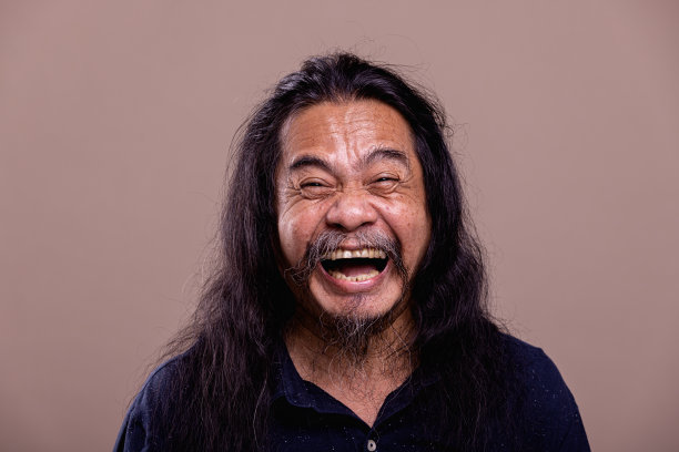 长发亚洲业余男子肖像。笑了。图片下载