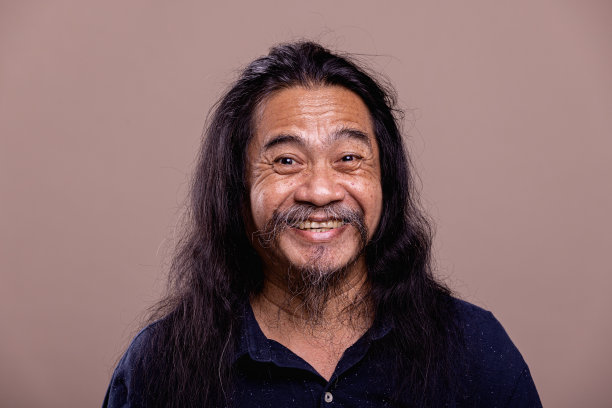 长发亚洲业余男子肖像。微笑图片下载