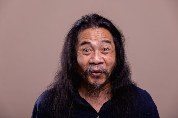 长发亚洲业余男子肖像。惊喜。图片下载