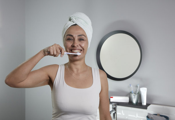 一位中年妇女微笑着对着镜头刷牙图片下载