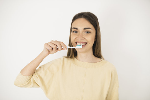 一个年轻女人清洁她美丽的牙齿的肖像图片下载