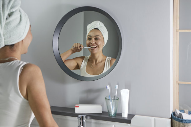 中年妇女刷牙时的倒影图片下载