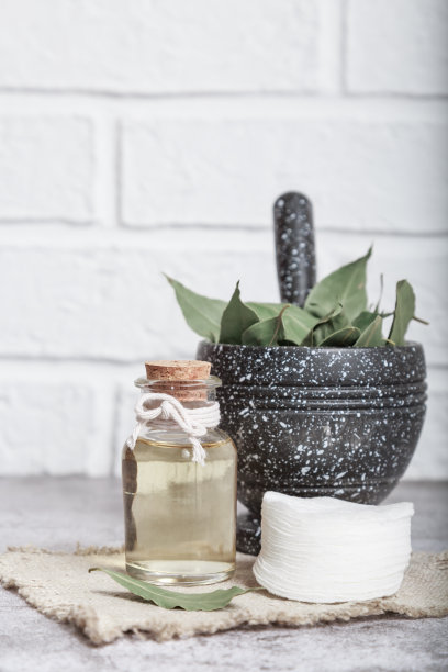 玻璃瓶装月桂天然按摩油。化妆品自制的补药。月桂叶和杵放在臼里图片下载