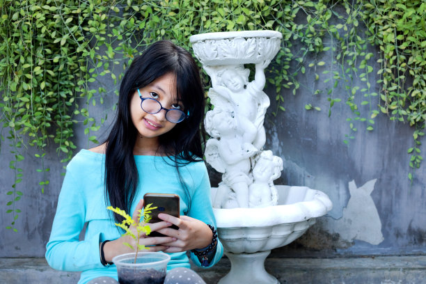 9岁的泰国少女正在拍摄花园里的植物图片下载