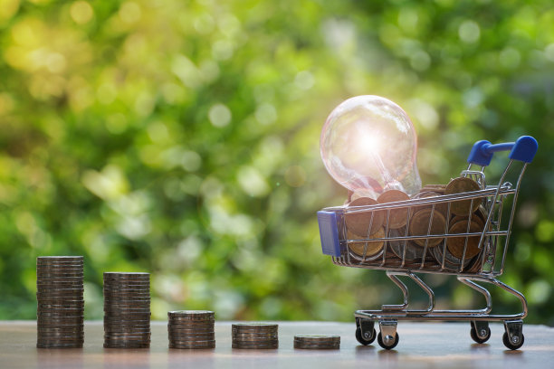 灯泡与硬币堆叠增加业务增长。企业可持续发展的财务理念。图片下载