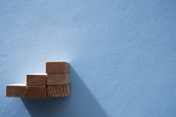 业务成长，业务成功或职业道路成功的概念。蓝色背景上，木块排列成楼梯形状。图片下载