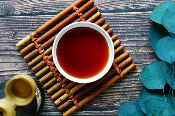 酱油在一个容器与叶木制背景图片下载