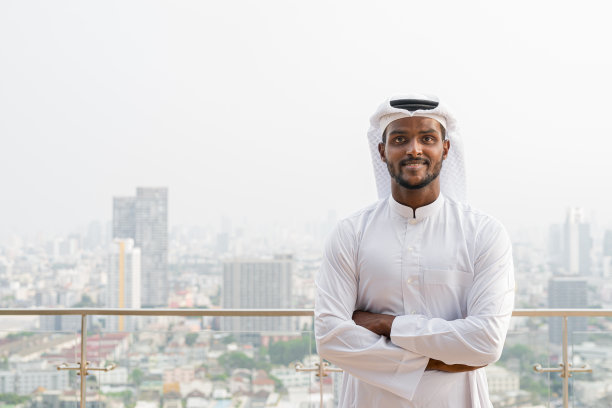 非洲穆斯林男子的肖像，穿着宗教服装，围巾在城市的屋顶图片下载