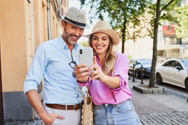 这对时尚情侣正在欧洲的夏日街道上自拍图片下载