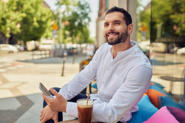 英俊的年轻男子在城市的咖啡休息的肖像图片下载