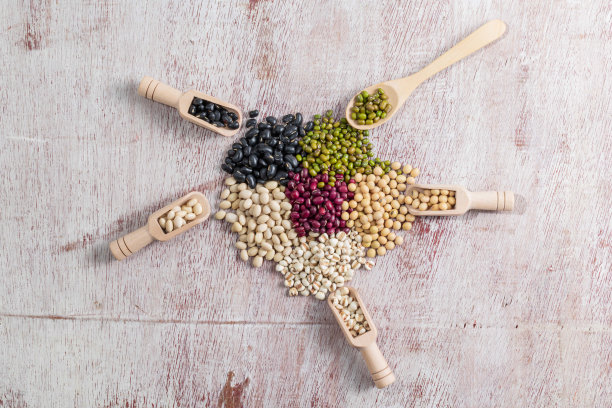 在木材背景上混合豆类。图片下载