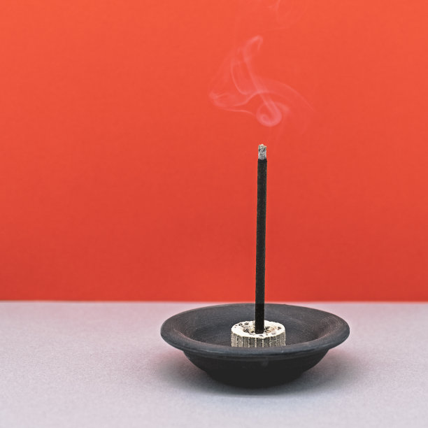 在红色背景的陶瓷烛台上烧香素材图片