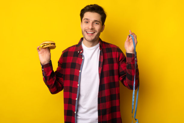 有趣的年轻人在工作室拿着汉堡和卷尺图片下载