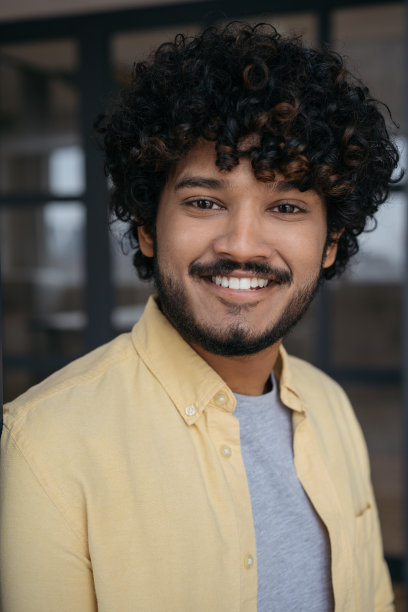 站在现代办公室里看着摄像机的商人。英俊微笑的印度学生的肖像。教育的概念图片下载