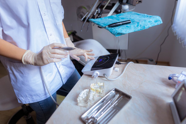 无法识别的牙科助手调整牙科设备图片下载