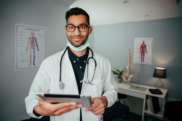 混血男护士站在办公室拿着数码平板电脑图片下载