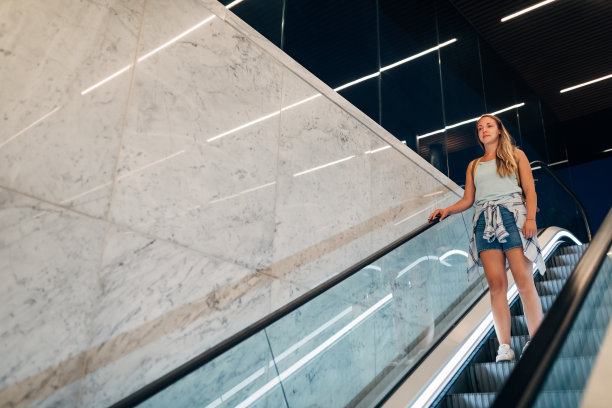 一个快乐的千禧一代女性在城市的地铁站里购物。图片下载