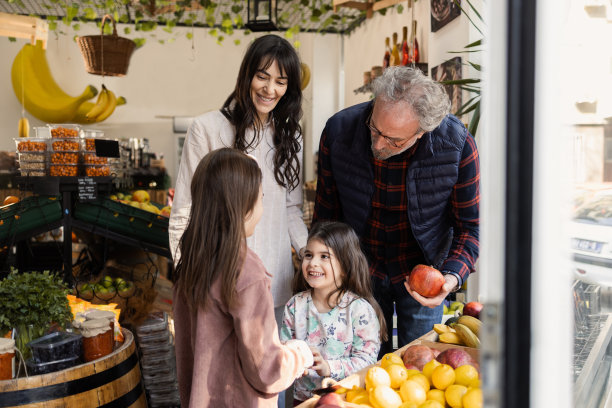 两个女孩和她们的妈妈在水果蔬菜店遇到了一位年长的邻居图片下载