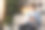 一名男孩在家教英语时使用智能手机。一个穿着牛仔衬衫的年轻人坐在客厅的沙发上，读着智能手机屏幕上的信息图片下载