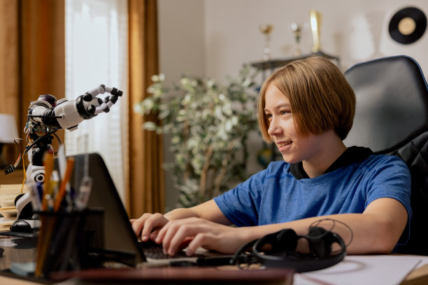 聪明的小男孩在笔记本电脑上做作业。一个快乐的青少年浏览教育材料，在社交媒体上聊天，为学校考试学习图片下载