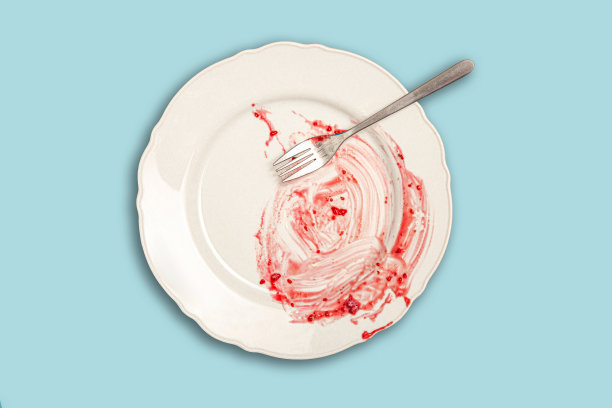 白色的空盘子里有一块剩下的蛋糕。混乱的盘子。图片下载