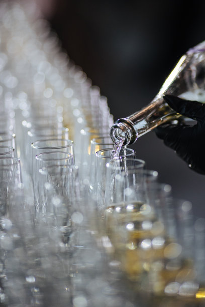 香槟从瓶子里倒进玻璃杯里。飞溅和滴。概念度假图片下载