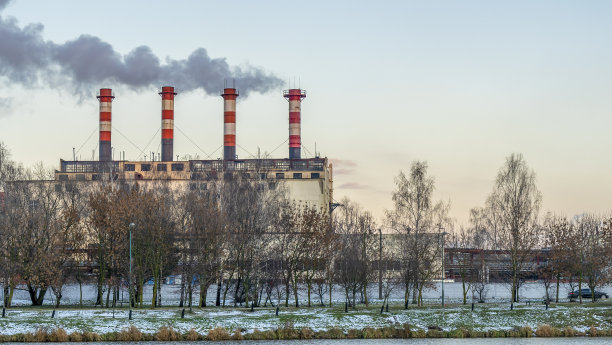 冬季带水库的电站。美丽的海边冬日夕阳和冒烟的工厂烟囱。图片下载