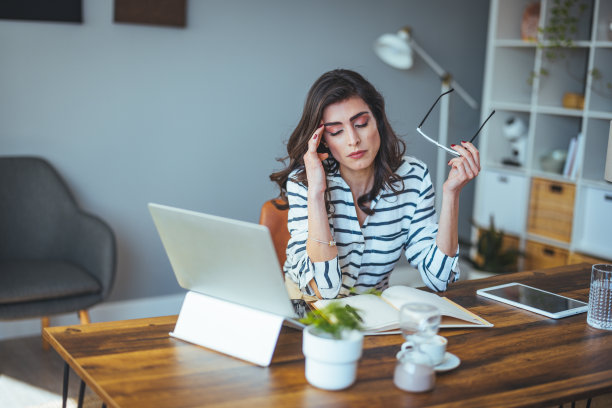 这张照片拍摄的是一位年轻的女商人，在办公室工作时看起来压力很大。图片下载