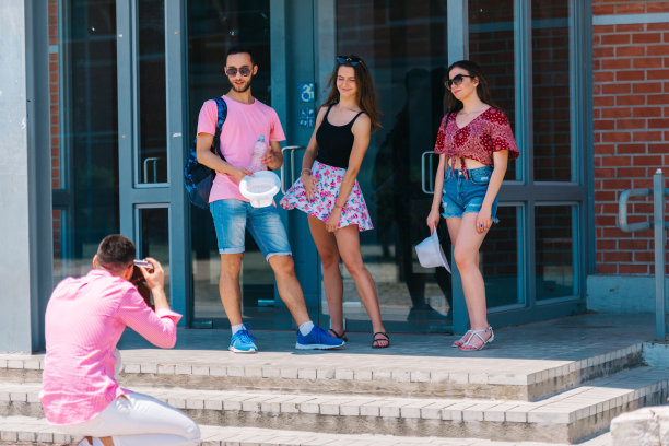 年轻快乐的游客在一座现代建筑前用旧的宝丽来相机拍照。图片下载