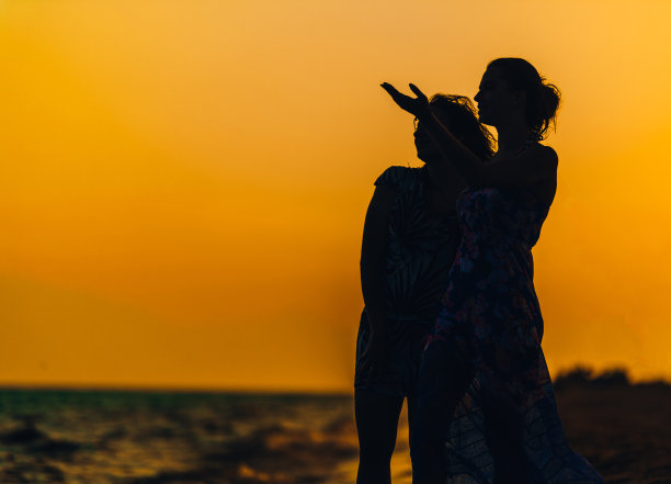 夕阳下沙滩上的年轻女子图片下载