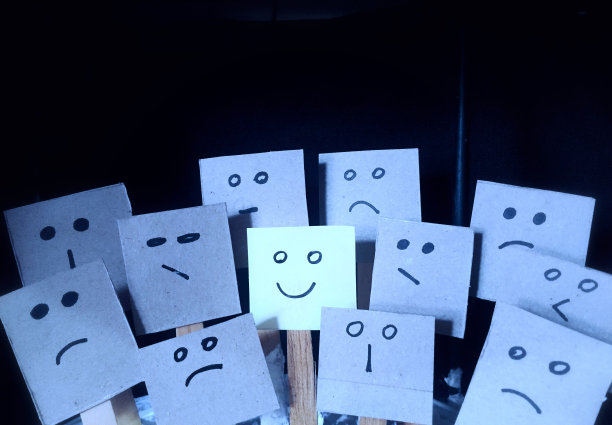 积极的态度概念，在许多糟糕或悲伤的面部表情中，手绘出快乐的表情。图片下载