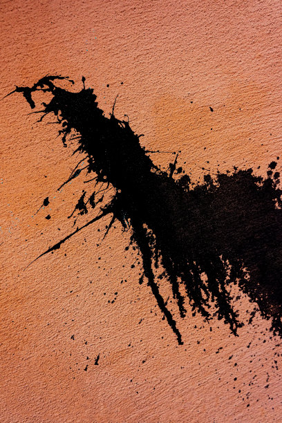 房子的一面粉红色墙壁上溅着黑色树脂。图片下载