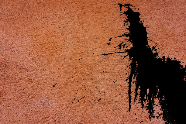 房子的一面粉红色墙壁上溅着黑色树脂。图片下载