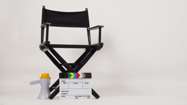 黑色导演椅子和彩虹白色拍板与黄色扩音器在白色背景图片下载