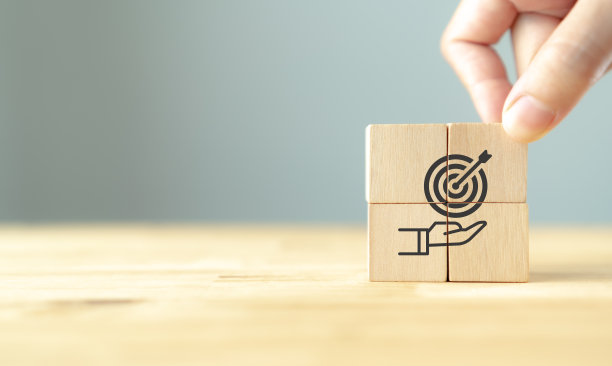 业务目标的概念。战略和目标的实现。手把木制可爱的目标，目标图标在灰色的背景。商业计划，共同目标，商业远景，计划和战略。图片下载