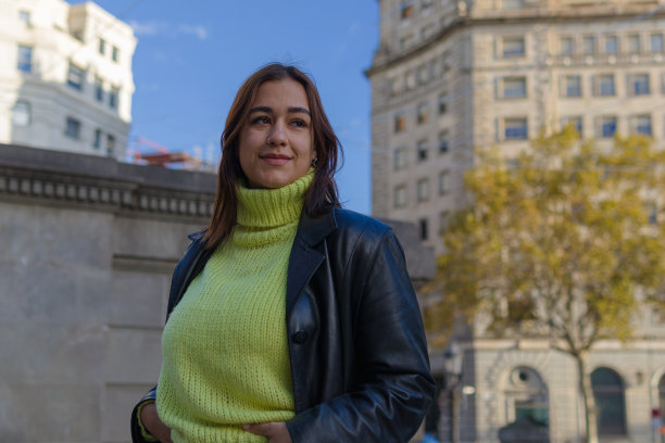 西班牙妇女站在城市中心，望向别处图片下载