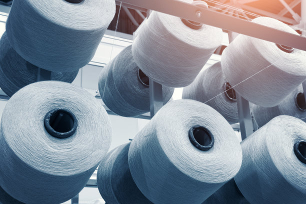 工业纺织制造机器上的纺织纱线的卷筒和蓝线图片下载