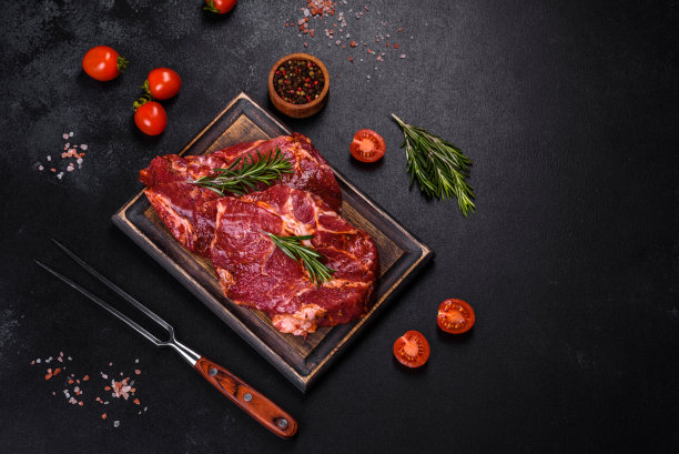 生的有机大理石牛排与香料在木制砧板上图片下载