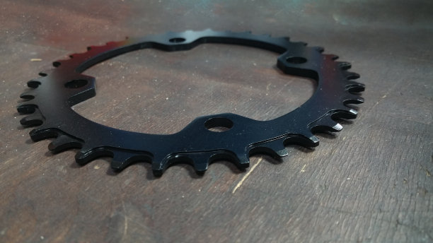 照片近距离-自行车链轮-在一个黑暗的木材背景图片下载