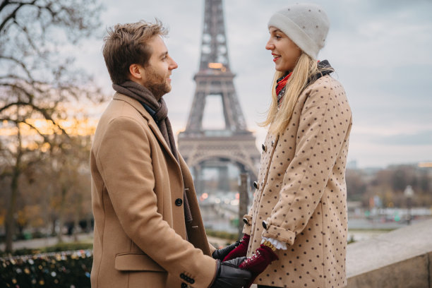 夫妻对视，女人站在楼梯上想要更高，背景是埃菲尔铁塔图片下载