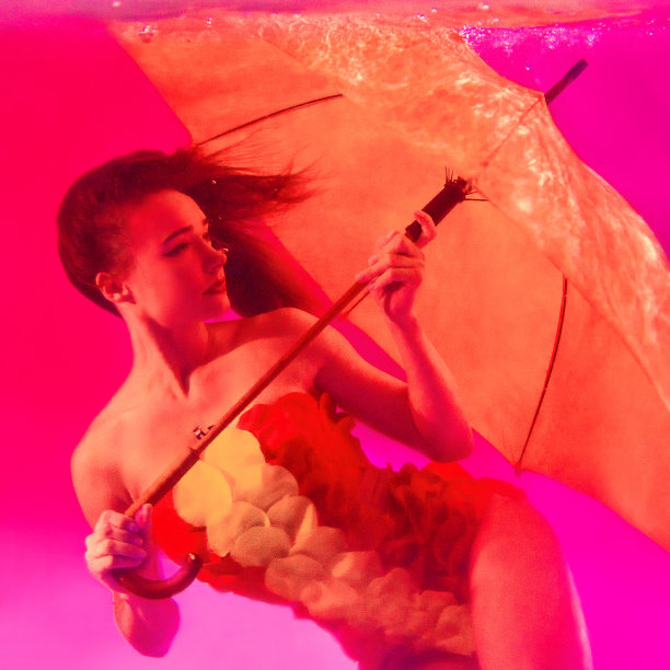 美丽惊人的时尚漂亮的年轻女子在游泳套装与伞在游泳池水下。时尚、艺术、购物理念图片下载