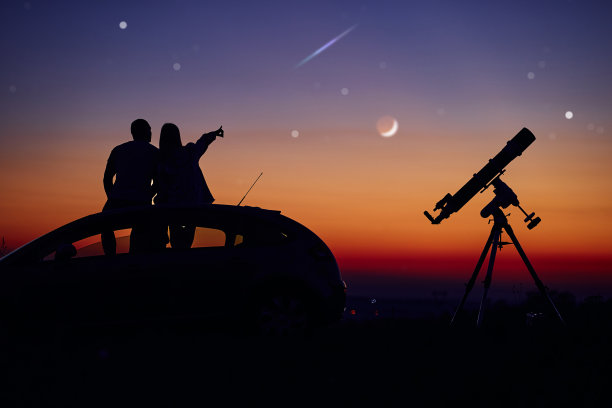 一对夫妇用天文望远镜一起看星星。图片下载